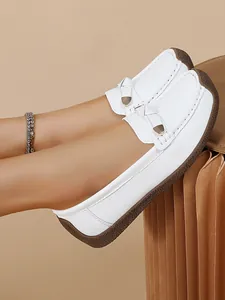 Detailed view of stylish white soft-sole loafers for women featuring metal buckle