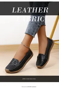 Detailopname van zwarte leren loafers met bloemendecoratie en zachte rubberen zool