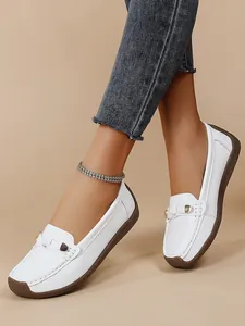Detail of white women's soft sole loafers showing textured rubber sole and slip-on design