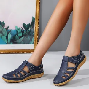 Détail de sandales de plage bleues ajourées portées par un mannequin dans un décor chic.