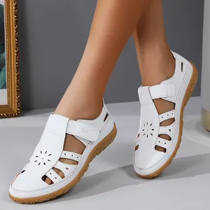 Détail de sandales plates blanches ajourées avec une semelle en caoutchouc souple et douce