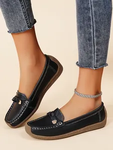 Detail of black slip-on moccasins with contrast stitching and soft textured sole.