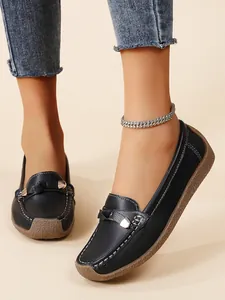 Close-up of black leather moccasins with soft non-slip soles on a model's feet