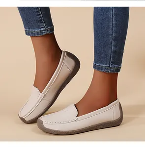 Primer plano de mocasines blancos cómodos para mujer con suelas marrones suaves
