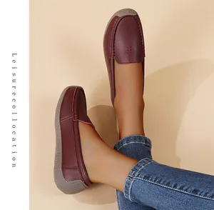 Mocasines cómodos de color burdeos para mujer con vaqueros sobre un fondo beige cálido