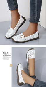 Detailed view of stylish white women's loafers with elegant floral hollow pattern design.