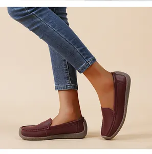 Primer plano de cómodos mocasines de mujer burdeos con piel suave y suela flexible.