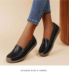 Primer plano de mocasines de cuero negro con suelas blandas y detalles de costuras blancas