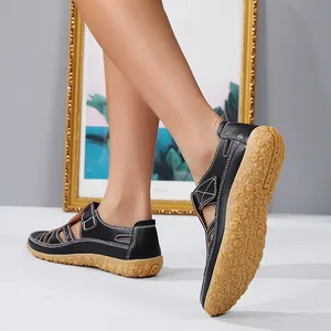 Détail des sandales plates noires pour femmes avec semelle antidérapante à motifs floraux.