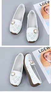 Close-up detail of white perforated loafers with gold buckle and soft textured brown sole