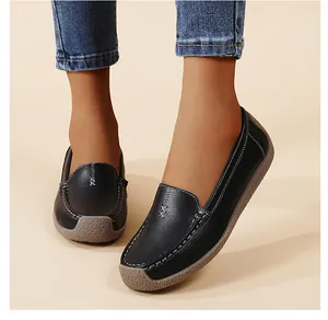 Primer plano de mocasines negros de cuero para mujer con costuras y suela de goma blanda