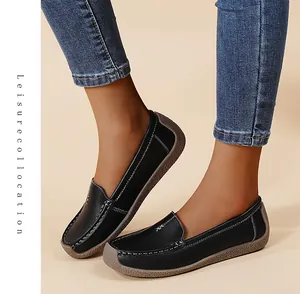 Mocasines elegantes de cuero negro para mujer con suelas suaves y vaqueros azul