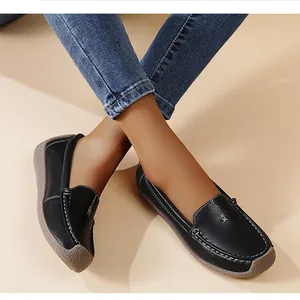 Vista detallada de mocasines de cuero negro para mujer con costuras blancas y suela flexible