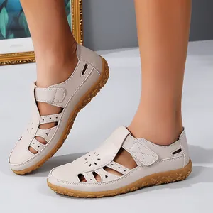 Vue détaillée de sandales plates beiges pour femmes avec design ajouré à motifs floraux