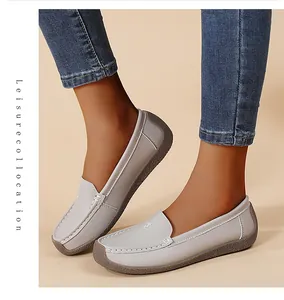 Primer plano de mocasines de cuero suave gris claro para mujer con suela de goma