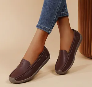 Primer plano de mocasines de cuero marrón para mujer con suelas blandas y textura.