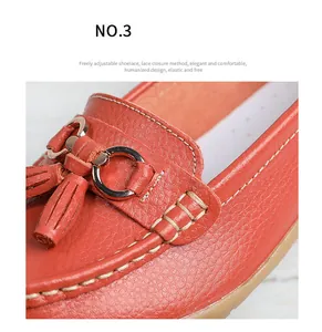 Macro detail of red leather loafer shoe featuring metallic buckle and tassel decorative stitching