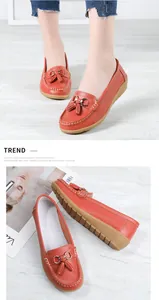 Close-up view of orange leather loafers with tassel and buckle details on soft soles