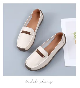 Gedetailleerd bovenaanzicht van crème leren loafers met bruine accenten en zachte zolen
