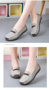 Detailweergave van comfortabele grijze leren loafers met contraststiksel op de voeten