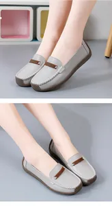 Detailweergave van grijze leren loafers met zachte zolen en witte handgestikte details