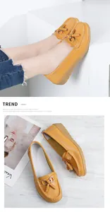 Detailed view of yellow leather loafers with elegant tassels and gold metal buckle