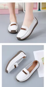 Detailweergave van witte leren loafers met zachte bruine rubberen zolen en stiksels.