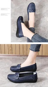 Close-up of navy blue perforated loafers with braided detail and soft flat sole