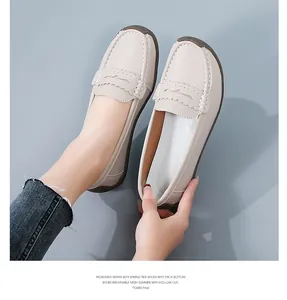 Detailed view of comfortable beige women's leather loafers featuring scalloped trim