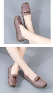 Gedetailleerd overzicht van paarse lederen loafers met witte stiksels en een zachte zool