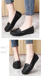 Close-up detail view of black women's flat loafers with breathable perforated patterns.