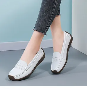 Close-up view of white leather loafers featuring a comfortable rubber sole for women