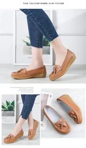 Detailed view of brown perforated leather loafers with tassels and buckle, soft wedge sole.