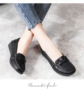 Close-up of comfortable black leather nurse shoes with bow detail on marble floor