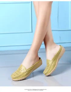 Muli con zeppa traforati verde oliva traspiranti indossati da una modella in studio