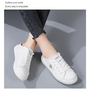Detailed view of white canvas slip-on sneakers with frayed edges shown being worn by a person