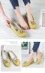 Detail of yellow leather loafers for women featuring decorative tassels and metallic buckle