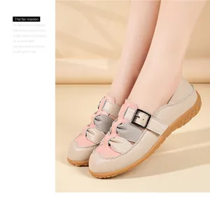 Primo piano di eleganti sandali piatti beige e rosa traforati con cinturino a fibbia
