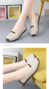 Detailweergave van comfortabele witte leren loafers met lasergesneden bloemmotieven.