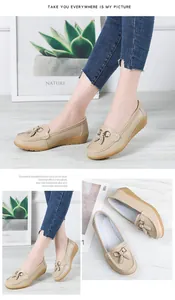 Detailed view of beige women's loafers with tassel accents and soft wedge sole.