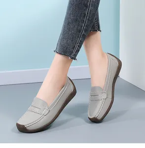Grey leather loafers with comfortable rubber sole shown from a side view on feet