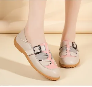 Dettaglio dei sandali piatti in pelle da donna con design traforato beige e rosa