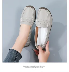 Detailed macro view of comfortable grey loafers featuring scalloped trim and gum sole.