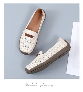 Gedetailleerd overzicht van gebroken witte geperforeerde leren loafers met zool.