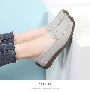 Close-up side view of grey leather loafers for women with textured brown comfort sole