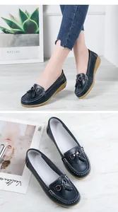 Detailed view of women's navy blue leather loafers with tassels and soft wedge soles
