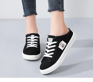 Women's black canvas mule sneakers with frayed edges and white laces for casual wear