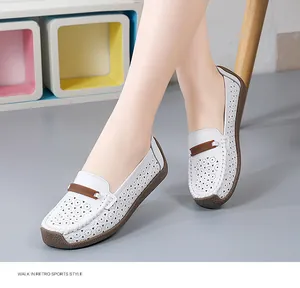 Detail van witte geperforeerde leren loafers met zachte bruine zool op een model