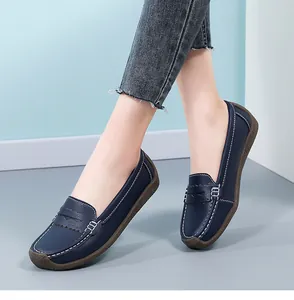 Detail view of navy blue women's loafers with white stitching and gum rubber sole