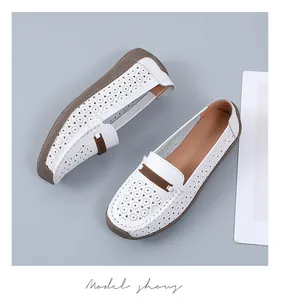 Detail van witte leren loafers met lasergesneden bloemmotieven en een zeer zachte zool.